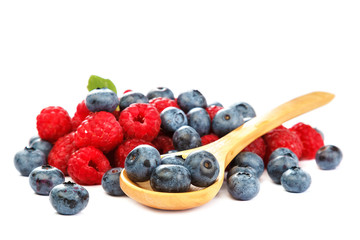 Fresh blueberries and raspberries with a wooden spoon