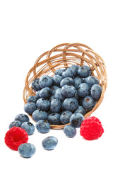 Fresh blueberries and raspberries in wicker baskets