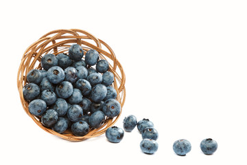 Fresh blueberries in a wicker basket on a white background