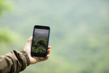 Hiker hands taking picture with mobile phone in spring nature