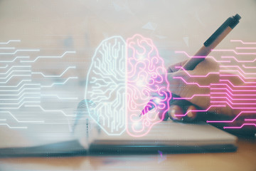 Double exposure of writing hand on background with brain hologram. Concept of learning.