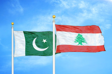 Pakistan and Lebanon two flags on flagpoles and blue cloudy sky