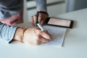 Woman making a shopping list in the kitchen