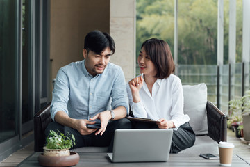 Two young Asian business men and women are working