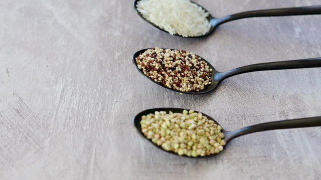 healthy plant-based diet, spoons lined up on kitchen counter with mixed grains and carbs including buckwheat quinoa rice and breadcrumbs and camera panning vertically