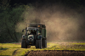 tractor at the field at sunset with dust
