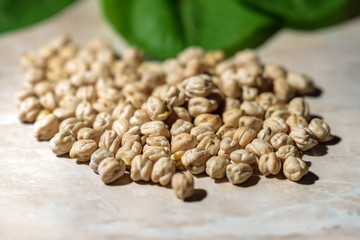 pea seeds and green leaves on a white wooden background