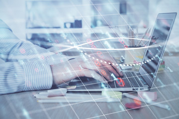 Double exposure of stock market graph with man working on laptop on background. Concept of...