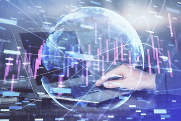 Double exposure of stock market graph with man working on laptop on background. Concept of financial analysis.