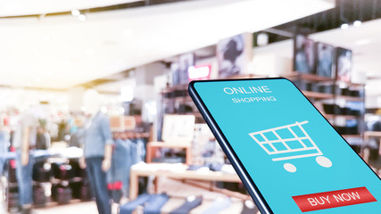  smartphone against blur of shop background with word online shopping buy now.