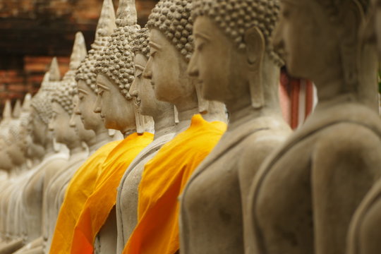 buddha statues in thailand with orange uniform 