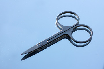 Mirrored manicure scissors on white background 