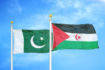 Pakistan and Western Sahara two flags on flagpoles and blue cloudy sky