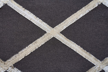 Fototapeta na wymiar gray fabric with sewn fringe in diamond shape