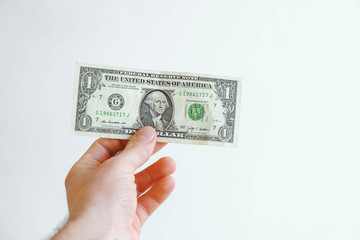 One dollar in hand on a white background. Copy, empty space for text
