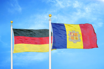 Germany and Andorra two flags on flagpoles and blue cloudy sky