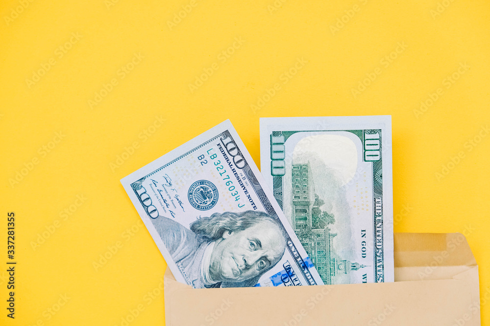 Wall mural Two hundred dollars in an envelope on a yellow background. Copy, empty space for text