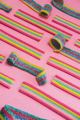Rainbow chewable candy gums on pink background. Geometric pattern. Flat lay, top view. Close up.