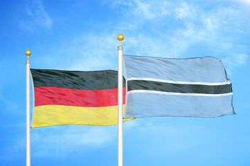 Germany and Botswana two flags on flagpoles and blue cloudy sky