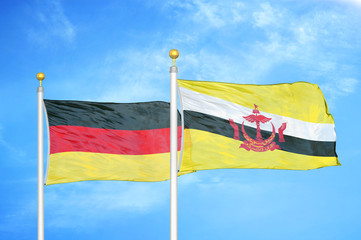 Germany and Brunei two flags on flagpoles and blue cloudy sky
