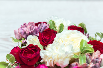 Red and white roses in a gift box on white wooden table. Flowers macro banner with copy space. Spring floral background.