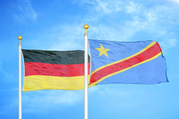 Germany and Congo Democratic Republic two flags on flagpoles and blue cloudy sky