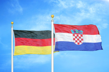 Germany and Croatia two flags on flagpoles and blue cloudy sky