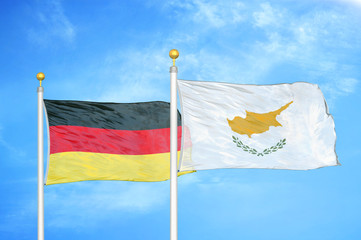 Germany and Cyprus two flags on flagpoles and blue cloudy sky