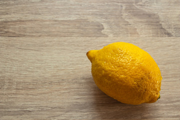 lemon on a wooden background in the corner of the frame closeup