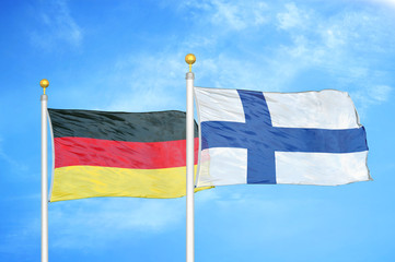 Germany and Finland two flags on flagpoles and blue cloudy sky