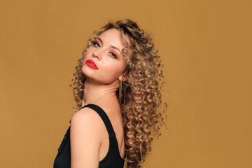 beautiful young woman   with curl hair  posing  on beige  background - Image