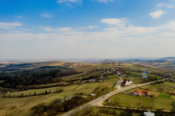 Fototapeta na wymiar Countryside road, surrounded by lush green nature - Top down aerial image
