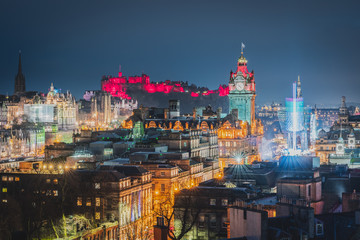 The city of Edinburgh at night with Edinburgh Castle illuminated in red with Christmas attractions. Stunning view from Calton Hill. Scotland, UK