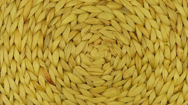 The braided mat spins on the stand. View from above. Can be used as a background.