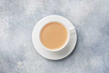 A Cup of coffee with milk in the center of the table. Top view.