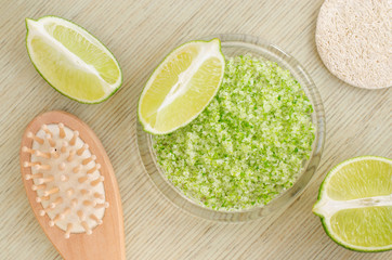 Homemade lime and sea salt exfoliating scrub (bath salt, foot soak). DIY citrus beauty treatment and spa recipe. Top view, copy space.