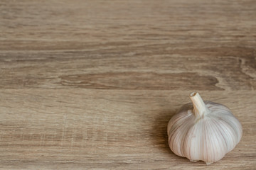 one white winter garlic close-up on a wooden background  in the right corner of the frame