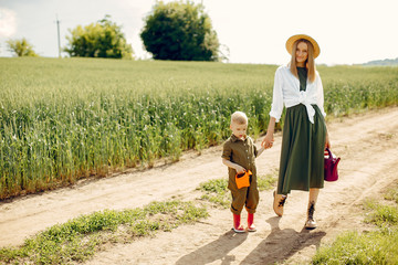Family gardening. Lady in a green dress. Mother with little son