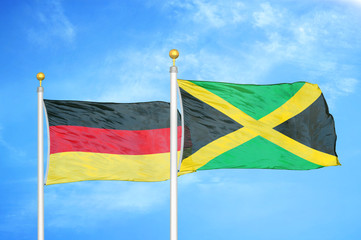 Germany and Jamaica two flags on flagpoles and blue cloudy sky
