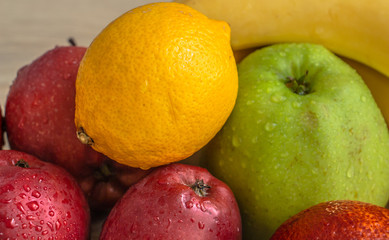 Naklejka na ściany i meble apples, bananas, lemon and oranges on a wooden table