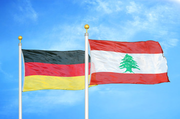 Germany and Lebanon two flags on flagpoles and blue cloudy sky