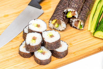 Sushi roll Japanese food maki on bamboo board next to knife