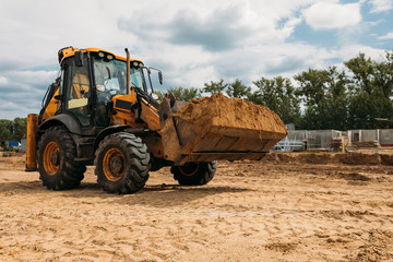 Obraz premium yellow tractor at a construction site on a sunny day