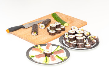 Sushi roll Japanese food rolls on board next to sashimi plate