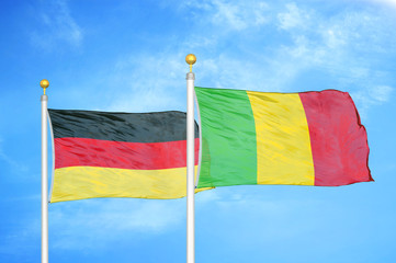 Germany and Mali two flags on flagpoles and blue cloudy sky