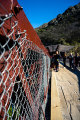 Kawarau Bridge, New Zealand, October 6, 2019: Close-up of the bridge fence with boys in the...