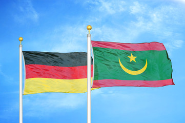 Germany and Mauritania two flags on flagpoles and blue cloudy sky