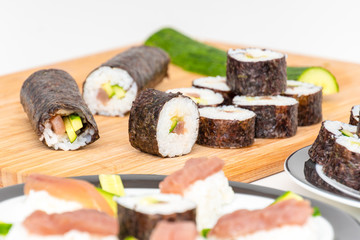Tuna Sushi Japanese food maki on bamboo board with sashimi in foreground