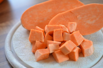 raw sweet potatoes on a wooden chopping board