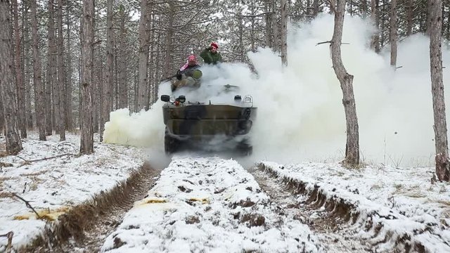 Airsoft. Through the smoke goes armored personnel carrier with soldiers